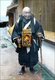 Japan: A mendicant pilgrim carrying a bell and a portable shrine around his neck, 1890s